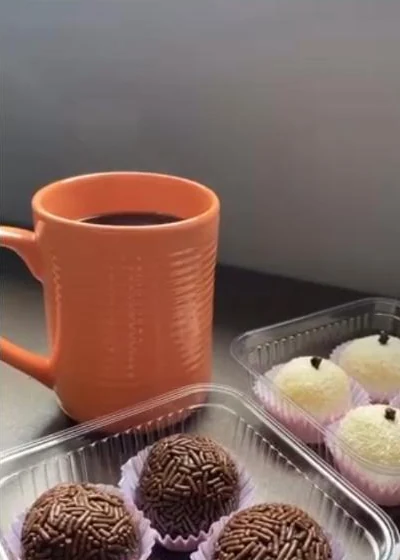 Brigadeiros e beijinhos ao lado de uma xícara de café